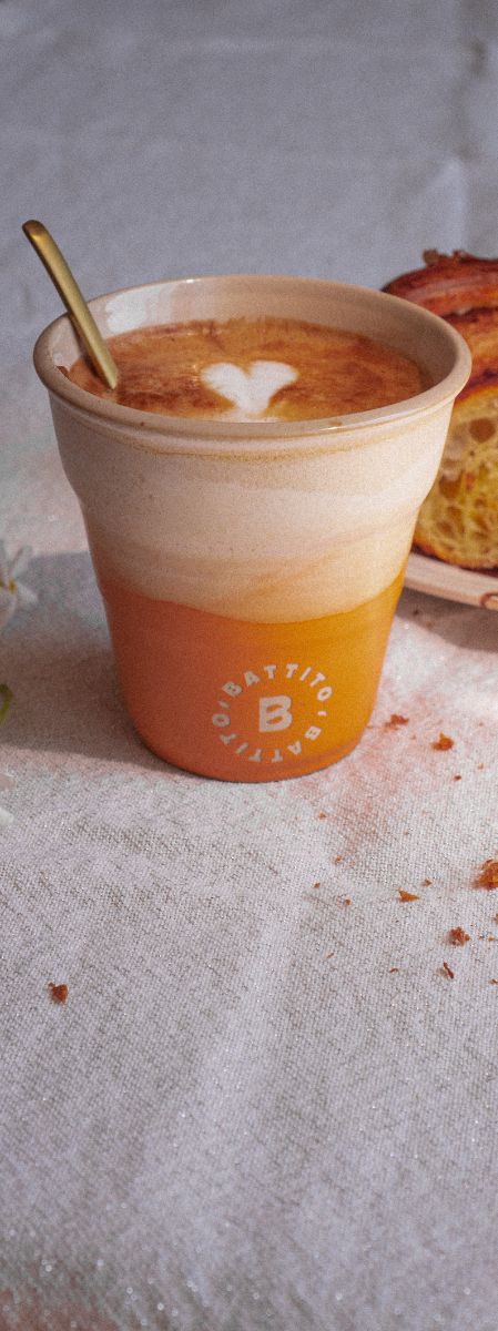 Cappuccino van Battito geserveerd met Italiaanse cornetto op wit tafelkleed