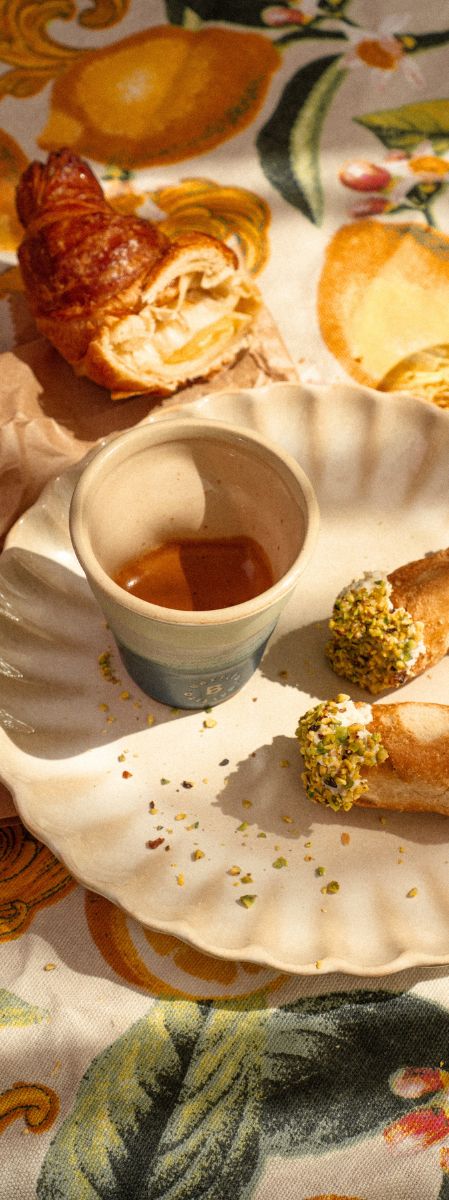 Espresso van Battito geserveerd met Italiaanse cornetto en cannoli op een tafelkleed met citroenen 